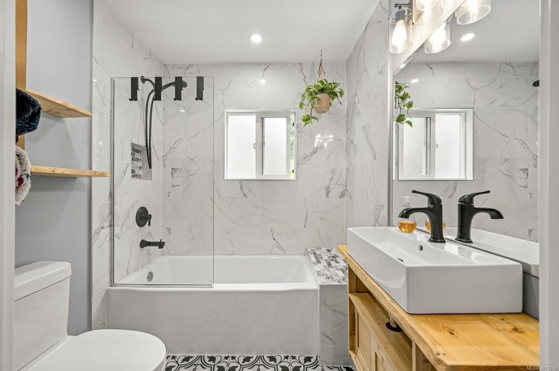 Renovated bathroom with marble-look tile and wood vanity